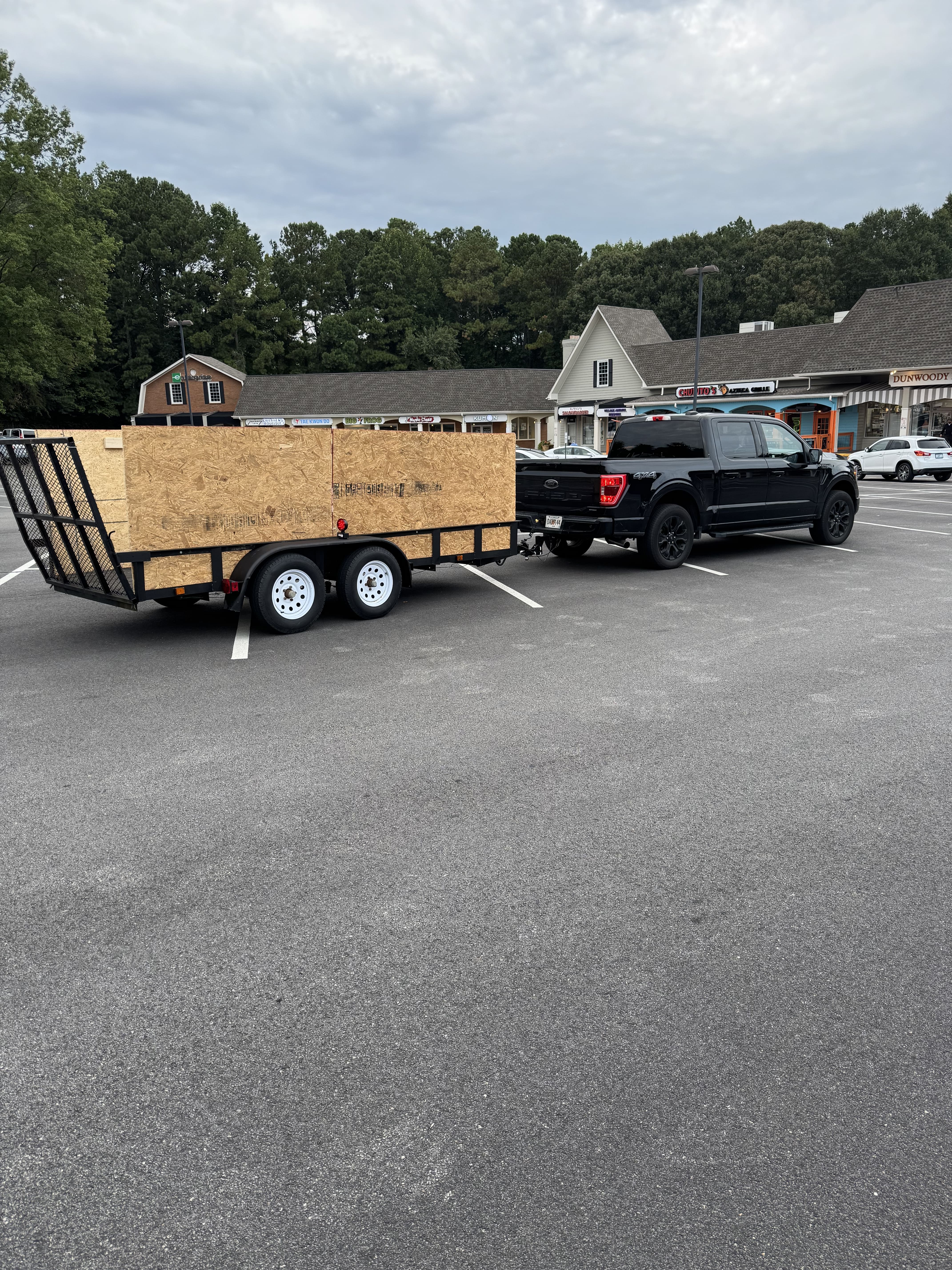 Debris Dusters junk removal truck serving Atlanta GA showing volume-based pricing for furniture and debris hauling